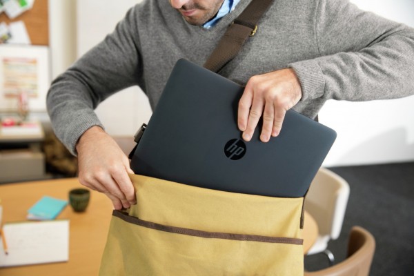 Man inserting the HP EliteBook 840/845 into messenger bag